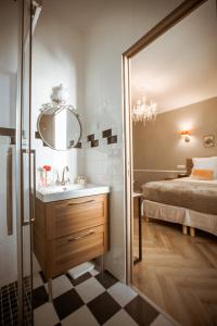 a bathroom with a sink and a bed and a mirror at La Maison Gobert Paris Hotel Particulier in Paris
