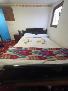 ein Bett mit einer bunten Decke darüber in der Unterkunft UMAR HOSTEL in Samarkand
