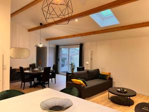a living room with a couch and a dining room at L'Escapade moderne in Gerzat