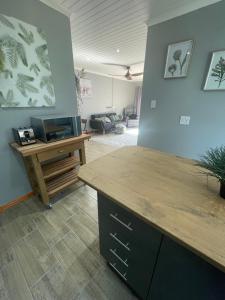 a kitchen with a wooden counter and a living room at PINE COTTAGE Self catering fully equipped 2 bedroom, Queen bed 3 singles 65sqm cosy private cottage in Durban