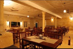 um restaurante com mesas e cadeiras de madeira numa sala em Royal Adventure Camp & Resort em Jaisalmer