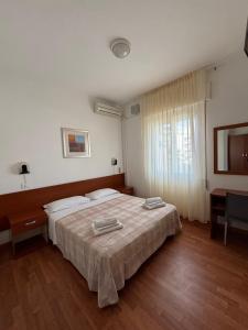 1 dormitorio con cama, mesa y ventana en Garnì Garten en Milano Marittima