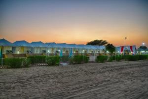 Royal Adventure Camp & Resort في جيلسامر: صف من الخيام على الشاطئ عند غروب الشمس