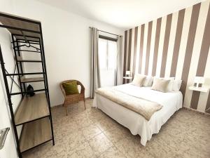 Un dormitorio con una cama y una estantería. en Mahostly Apartamento Comillas PG, en Arrecife