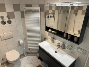 uma casa de banho com um lavatório, um WC e um espelho. em Ferienwohnung Marianne Bergpanorama Eröffnung Juni 24 für Paare 60qm em Berchtesgaden