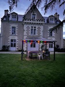 a picnic table in front of a large house at Clos de Joco - Gîte de groupe in Pas-de-Jeu