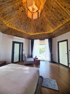 - une chambre avec un grand lit et un plafond en bois dans l'établissement Family Land Camping Resort, à Vang Vieng