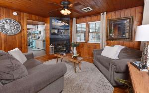 a living room with two couches and a clock on the wall at River Romance in Gatlinburg