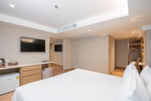 een hotelkamer met een bed en een flatscreen-tv bij Away Bangkok Riverside Kene in Bangkok
