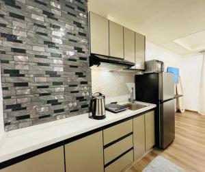 a kitchen with a refrigerator and a counter top at GOLDEN SUITES BAGUIO in Baguio