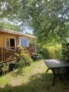 a house with a picnic table in front of it at Le Casita 3 ch, au calme, sur parcelle arborée in Lattes