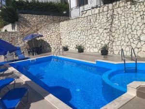 a swimming pool in front of a stone wall at Panorama Pearl in Balchik