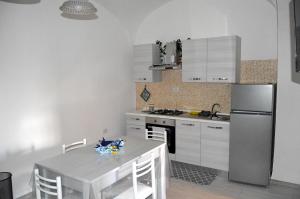 a kitchen with a table and a stainless steel refrigerator at Casa vacanza Città dei Papi Anagni in Anagni