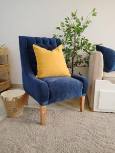 einen blauen Stuhl mit gelbem Kissen im Wohnzimmer in der Unterkunft Madinaty Luxury Apartments New cairo in Madinaty