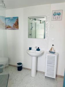 a white bathroom with a sink and a mirror at Duplex Chez Caro, 180m de la mer à Cayeux sur mer in Cayeux-sur-Mer