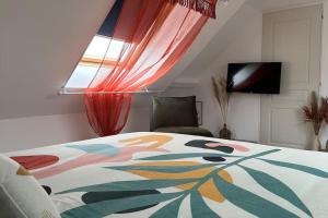 a bedroom with a bed with a colorful blanket at Duplex Chez Caro, 180m de la mer à Cayeux sur mer in Cayeux-sur-Mer