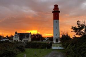 a red and white lighthouse in front of a house at Duplex Chez Caro, 180m de la mer à Cayeux sur mer in Cayeux-sur-Mer