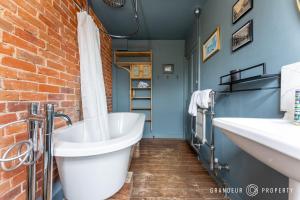 a bathroom with two sinks and a brick wall at The Blue House by Grandeur Property in Lymington +20 photos