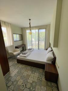 um quarto com uma cama grande e uma janela em Green Life Beach Resort Sozopol Two Bedroom Apartment em Sozopol