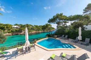 a swimming pool next to a body of water at Casa Ramon in Cala d´Or