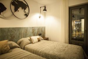 een slaapkamer met 2 bedden en een spiegel aan de muur bij La Aduana The Lodging Experience in Astorga