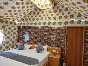 ジャイサルメールにあるRoyal Adventure Camp & Resortのレンガの壁、ベッド付きのベッドルーム1室