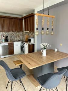 uma cozinha com uma mesa de madeira e cadeiras em Green Life Beach Resort Sozopol Two Bedroom Apartment em Sozopol