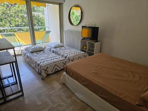 two beds sitting in a room with a window at Studio calme à 200m des plages in Cannes