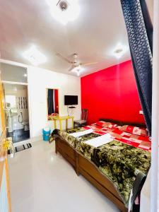 1 dormitorio con cama y pared roja en Hotel Chachoo Palace en Srinagar