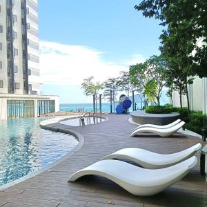 una piscina con due grandi sculture bianche accanto a un edificio di Covesign Suite a Kota Kinabalu