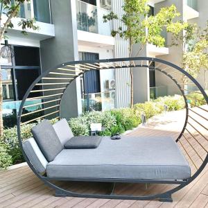 un letto a dondolo su una terrazza di fronte a un edificio di Covesign Suite a Kota Kinabalu