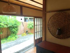 古民家の宿 鎌倉楽庵 في كاماكورا: غرفة بجدار مع نافذة ومرآة
