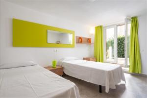 a bedroom with two beds and a large window at Casa Ramon in Cala d´Or