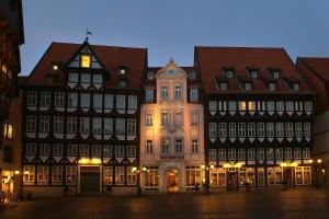 un groupe de bâtiments dans une rue la nuit dans l'établissement Van der Valk Hotel Hildesheim, à Hildesheim