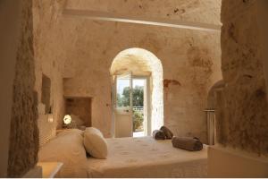 カステッラーナ・グロッテにあるTrulli&Dimore - Casette Pricciの石壁のベッドルーム1室