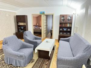 a living room with two chairs and a table at Chkalovka guest house with Sevan view in Sevan
