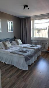 a bedroom with two beds and a large window at Hotel Bishops Arms Mora in Mora