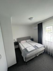1 dormitorio con cama y ventana en Hotel Ada - Otoka en Sarajevo
