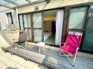 a porch with two chairs and a bed on it at 頭城1790民宿 in Toucheng