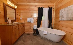 a wooden bathroom with a tub and a sink at A Wildflower Retreat in Gatlinburg