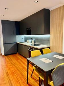 a kitchen with a table and yellow chairs in a kitchen at Lugar de Alegría, Pegado a Playa, 2 Hab, 6 p, Wifi - VUT-4241-AS in Gijón
