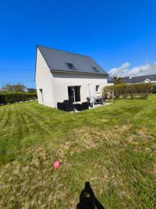 a house with a yard with a pink ball in the grass at Ty ar steredenn maison avec jardin , plage à pied in Plouarzel +9 photos