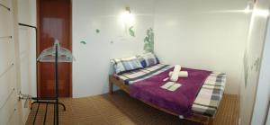 a bedroom with a bed with a purple blanket at Maligaya Maison in General Luna +24 photos