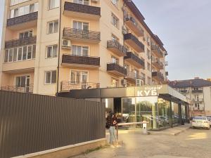 osoba stojąca przed wysokim budynkiem w obiekcie New loft style apartment w mieście Użhorod