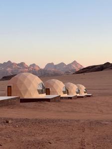 four domes in the desert with mountains in the background at Rum Star Desert Camp in Wadi Rum +61 photos