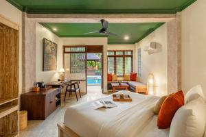 a bedroom with a large bed and a living room at Semana Residences by Cove in Ubud