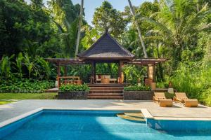 a gazebo with a swimming pool next to a resort at Semana Residences by Cove in Ubud