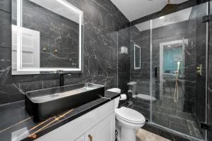 休斯顿Charming Downtown Studio - Ideal Location for Exploring Houston的黑色浴室设有水槽和卫生间