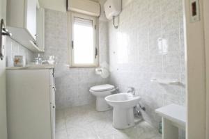 a white bathroom with a toilet and a sink at Villa Sofia in Botricello +11 photos