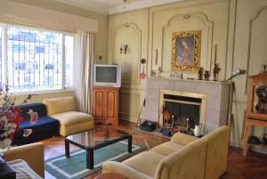 a living room with a fireplace and a tv at Travellers Inn in Quito